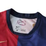Close-up of the neckline on a Barcelona x Coldplay (Special Release) jersey, featuring half red and half blue design with Nike logo.