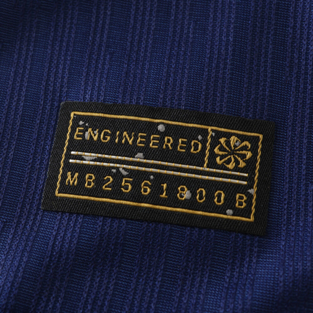 Close-up of Barcelona x Coldplay special release, player version jersey label with "Engineered" and serial number MB2561800.B.