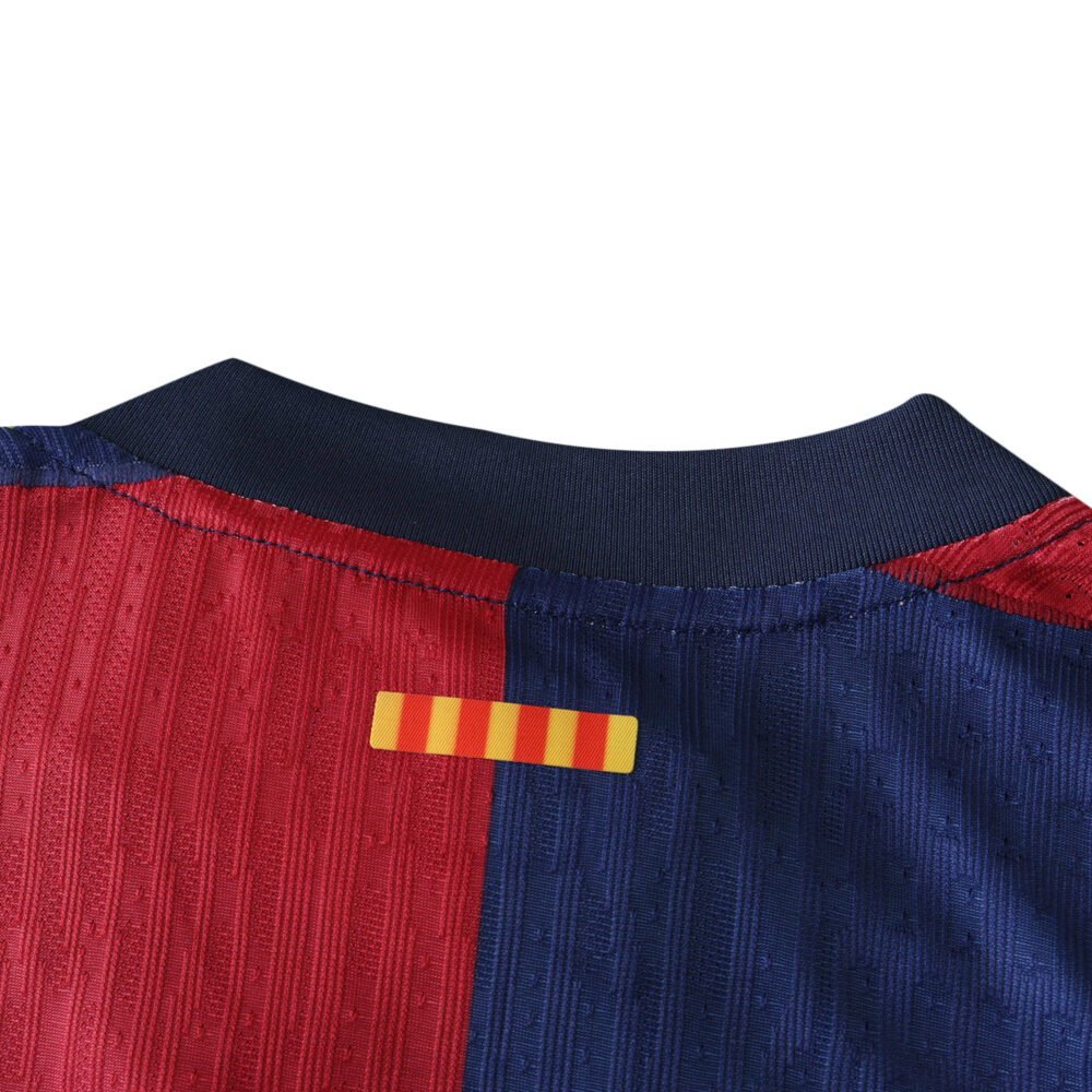 Close-up of Barcelona x Coldplay Player Version jersey, highlighting the red and blue collar with a small yellow-red striped detail.