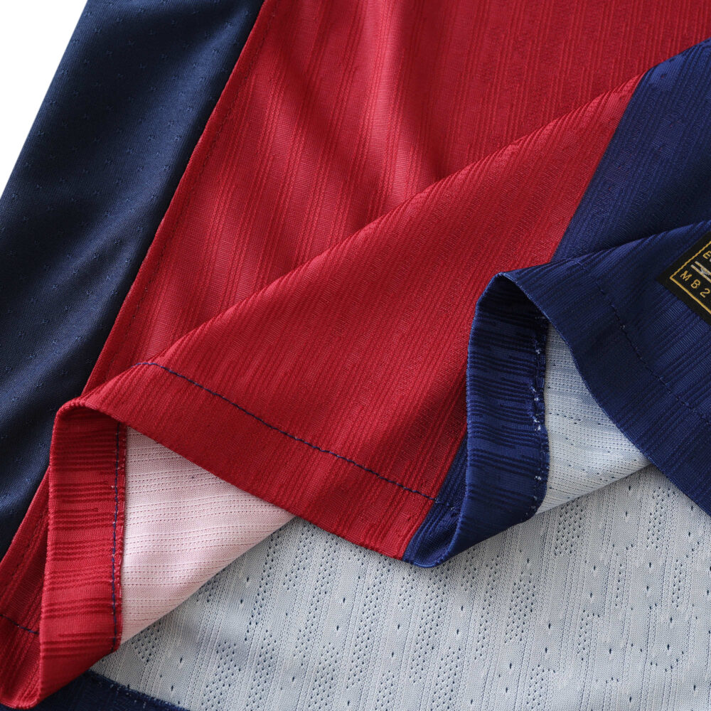 Close-up of Barcelona x Coldplay Player Version jersey fabric showing red and blue stitching.