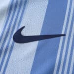 Close-up of the Nike logo on the Tottenham x Travis Scott (Special Release) Fan Version jersey, featuring blue and white stripes.