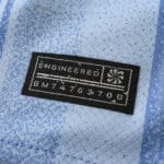 Close-up of the "Engineered" label on a Tottenham x Travis Scott Fan Version jersey, featuring unique code BM74763706.