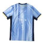 Tottenham x Travis Scott Player Version jersey, back view, blue with vertical stripes and "CACTUS JACK" text in white.