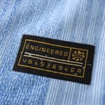 Close-up of a Tottenham x Travis Scott Player Version jersey tag with "ENGINEERED" and serial number VB4526940R.
