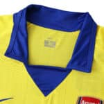 Close-up of the Arsenal Retro Away 2003/04 Fan Version jersey, highlighting the yellow fabric and blue collar.