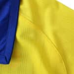 Close-up of the yellow and blue fabric from the Arsenal Retro Away 2003/04 Fan Version jersey.