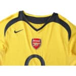 Arsenal Retro Away 2005/06 Fan Version jersey in yellow with the Arsenal emblem, Nike logo, and black details around the shoulders.