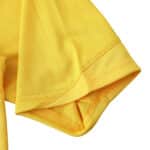 Close-up of the sleeve of the Arsenal Retro Away 2005/06 Fan Version jersey, showcasing its yellow fabric and stitching details.