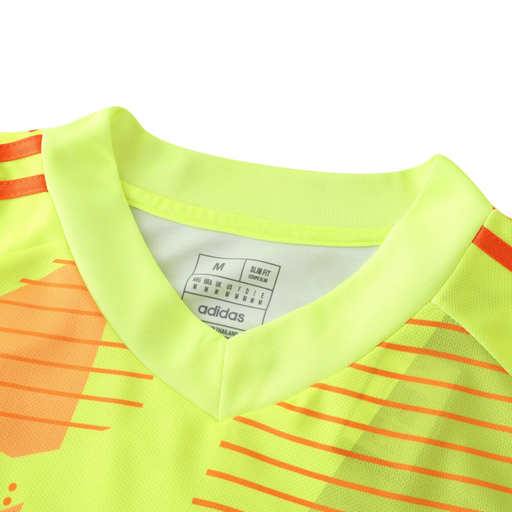 Close-up of the Bayern Munich 2024/25 goalie jersey; neon yellow with red accents and Adidas logo on the inner neck.