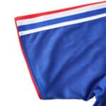 Close-up of a France Retro Home 2006 fan version jersey sleeve, featuring blue fabric with white and red trim detailing.