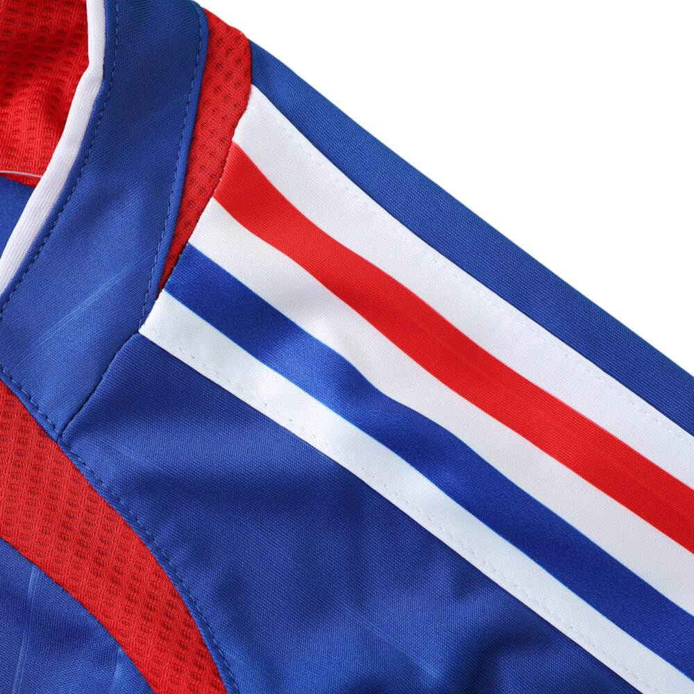 Close-up view of the sleeve of a France Retro Home 2006 fan version jersey in blue with red, white, and blue stripes.