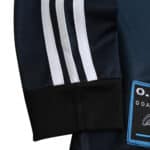 Close-up view of the sleeve and logo on a Germany Retro Goalkeeper 2002 Fan Version jersey, featuring white stripes.