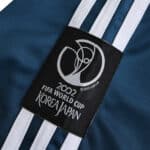 Close-up of Germany Retro Goalkeeper 2002 Fan Version jersey, featuring the 2002 FIFA World Cup Korea Japan emblem.