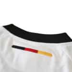 Close-up of the back collar detail of Germany Retro Home | 2002 Fan Version, showing the German flag colors embroidered.