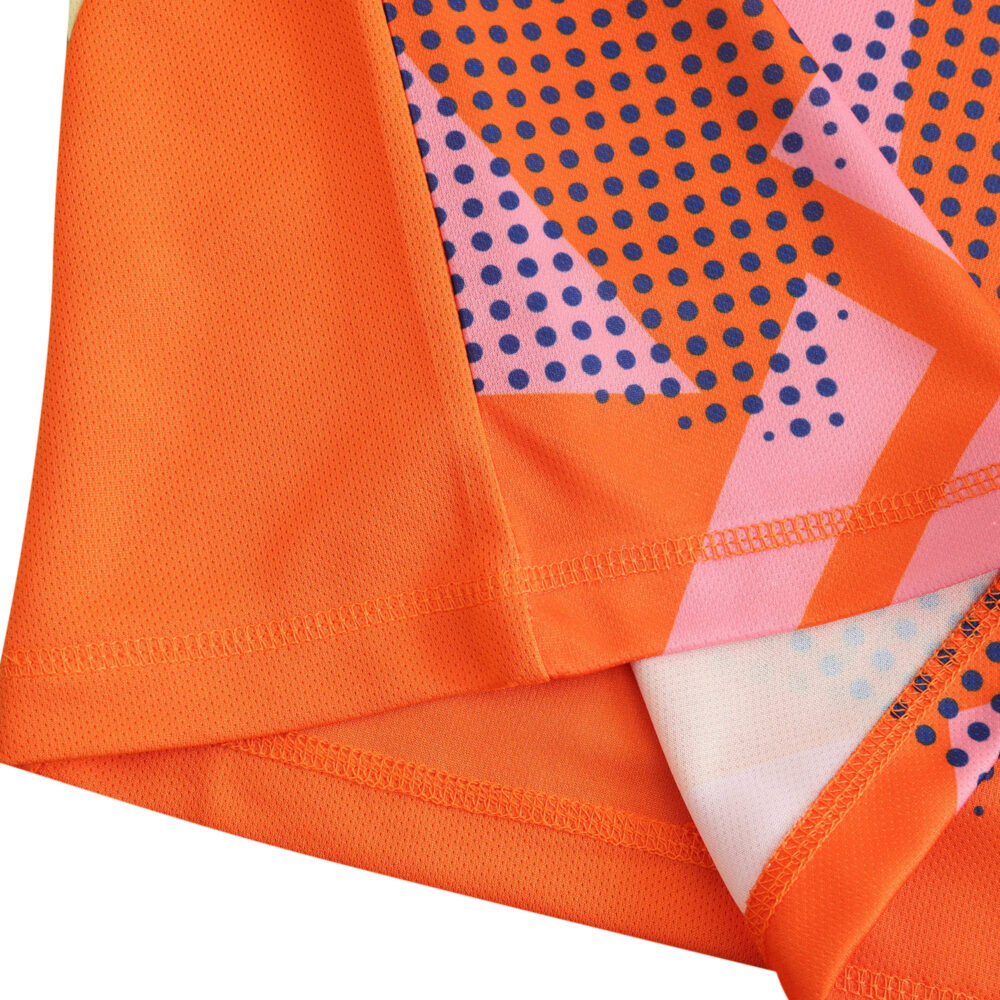 Close-up view of Italy Goalkeeper 2024 fan version jersey, showcasing vibrant orange fabric with geometric and dotted patterns.