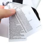 Care label on the Juventus Retro Home 2004/05 Fan Version jersey. Hand holding tags showing material composition in multiple languages.