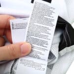 Close-up of the care label on a Juventus Retro Home 2004/05 Fan Version jersey, showing material composition and washing instructions.