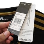 Close-up of hands holding the tags attached to a Juventus Retro Third 2015/16 Fan Version jersey.