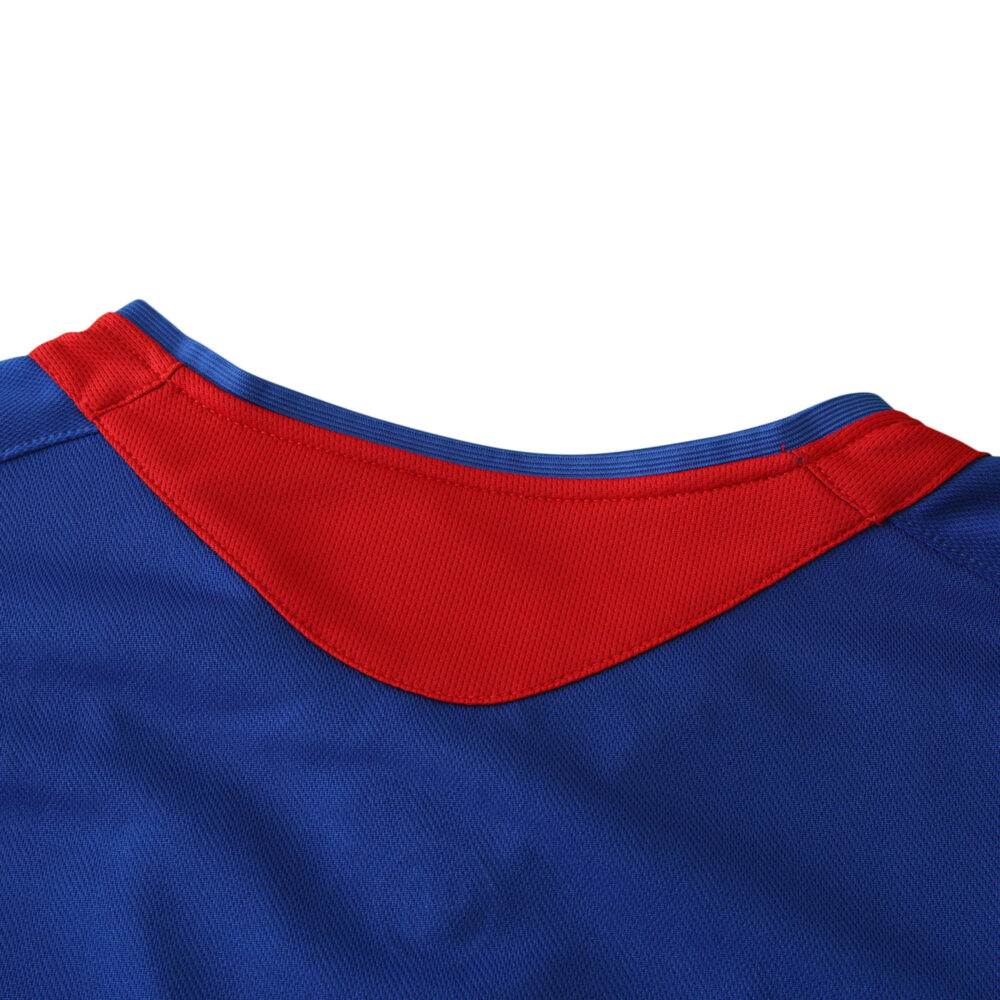 Close-up of the Manchester United Retro Away 2005/06 Fan Version jersey, highlighting its blue fabric and red collar detail.