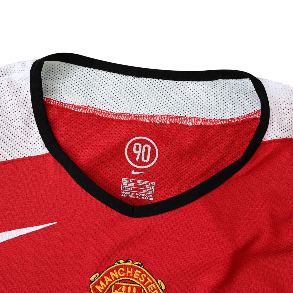 Close-up of Manchester United Retro Home 2004/05 Fan Version jersey collar with Nike logo and club badge in view.