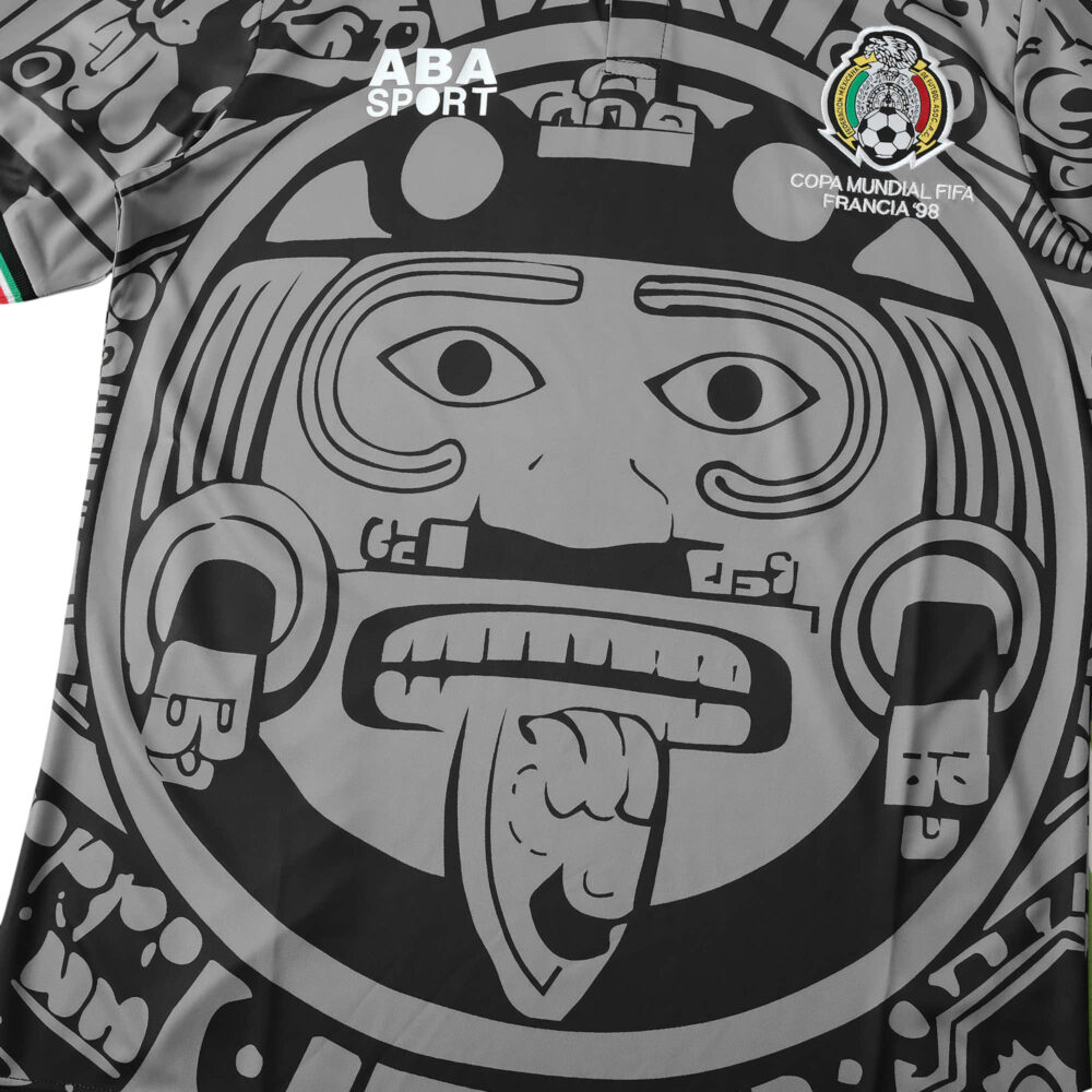 Close-up of the Mexico Retro Away 1998 Fan Version jersey, featuring Aztec calendar design and FIFA World Cup France 98 emblem.