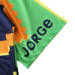 Close-up of the sleeve of Mexico Retro Goalkeeper Jersey 1995, showing "Jorge" on a green background with yellow and orange designs.