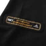 Close-up of the official "Real Madrid Authentic Licensed Product" label on a black retro away jersey for the 2001/02 season.