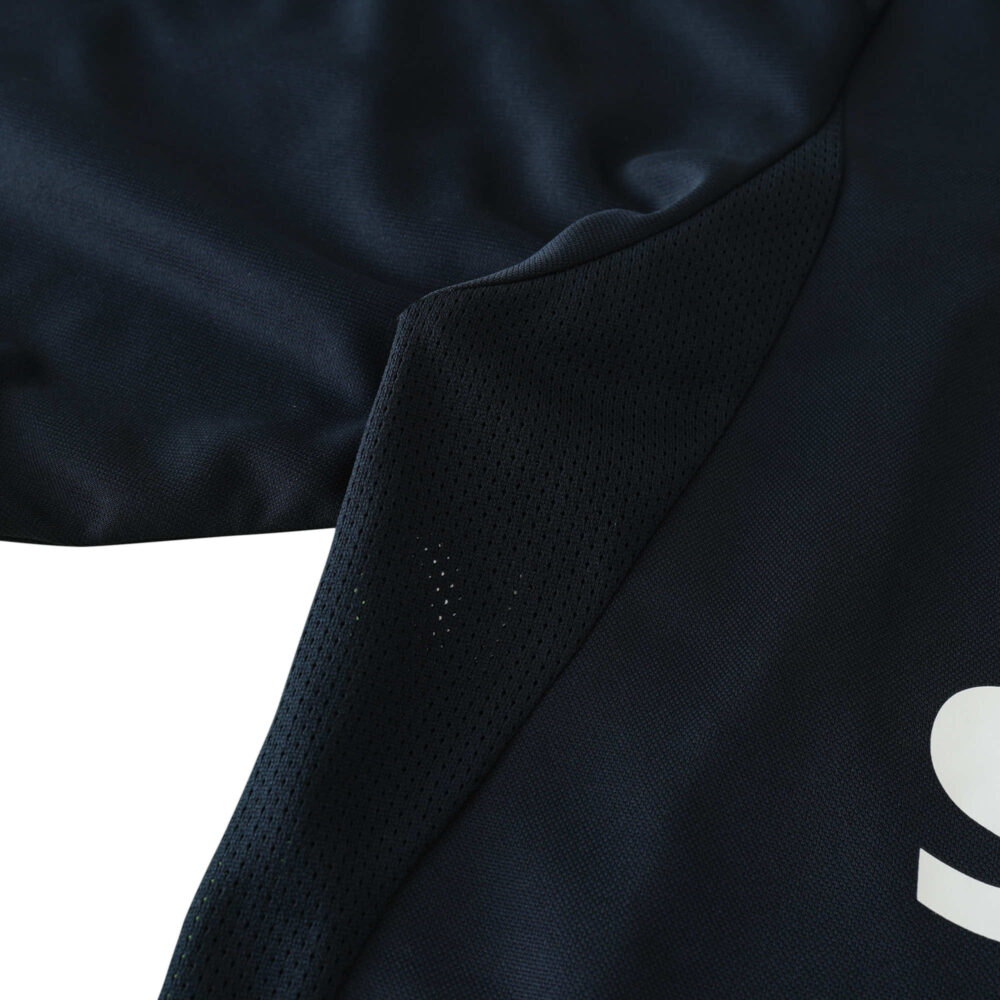 Close-up of Real Madrid Retro Away 2003/04 Fan Version jersey, showing black fabric texture and part of the white logo.