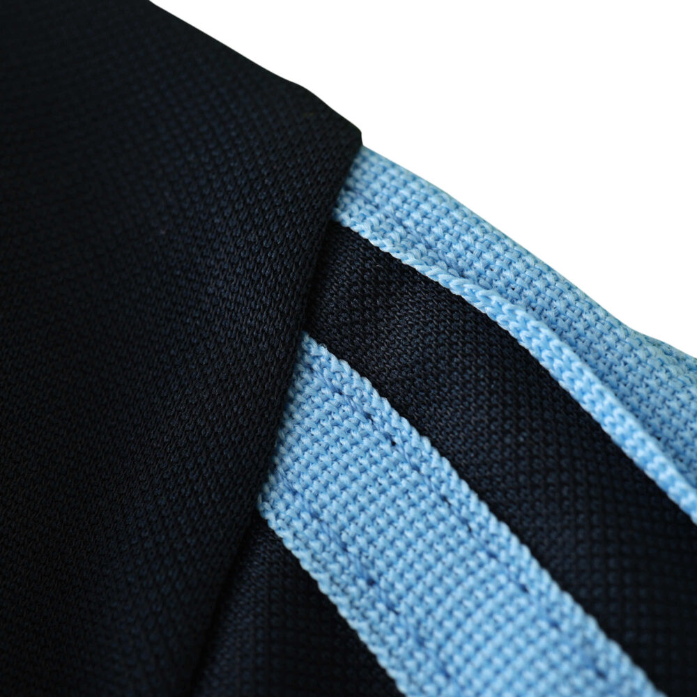 Close-up of the Real Madrid Retro Away 2003/04 Fan Version jersey, featuring black and sky-blue fabric detailing.
