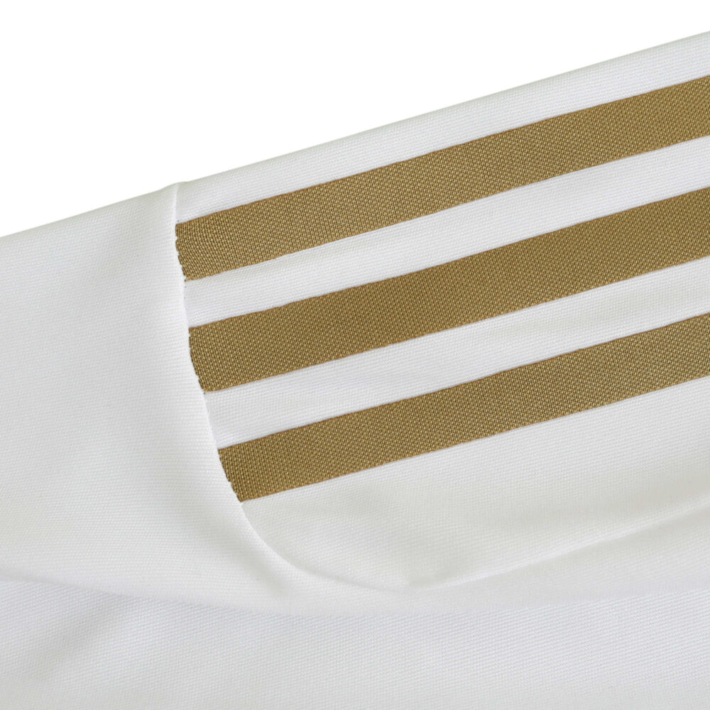 Close-up of Real Madrid Retro Home 2011/12 Player Version jersey showcasing three golden stripes on white fabric.