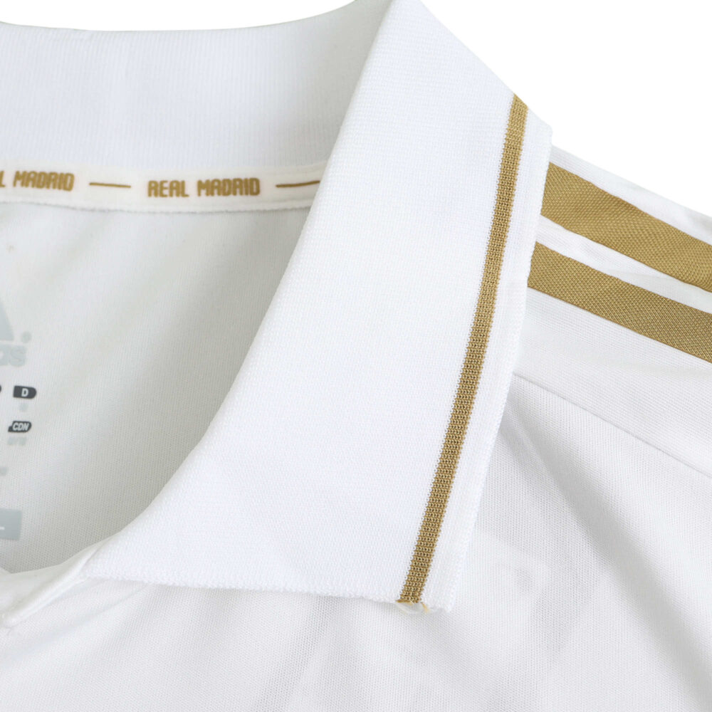 Close-up of the collar and shoulder area of Real Madrid Retro Home 2011/12 Player Version jersey, featuring gold stripes.