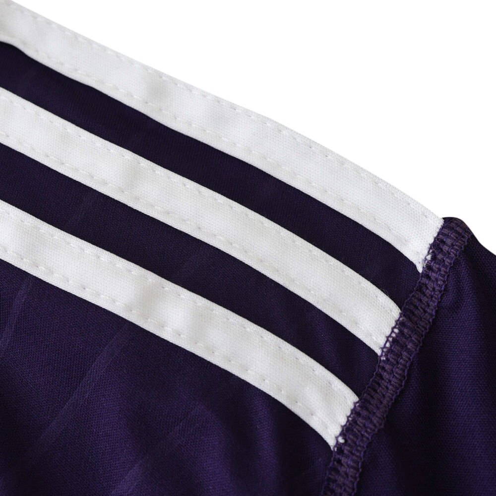 Close-up of the shoulder area on the Real Madrid Retro Third 2010/11 fan version jersey with iconic white stripes.