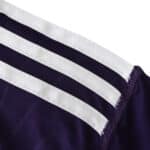 Close-up of the shoulder area on the Real Madrid Retro Third 2010/11 fan version jersey with iconic white stripes.