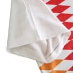 Close-up of the sleeve and shoulder area of the Spain Retro Away 1994 Fan Version jersey, showing red and orange geometric design.