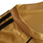 Close-up of the Spain Retro Away 2008 Fan Version jersey's collar and shoulder area, showing golden fabric with black stripes.