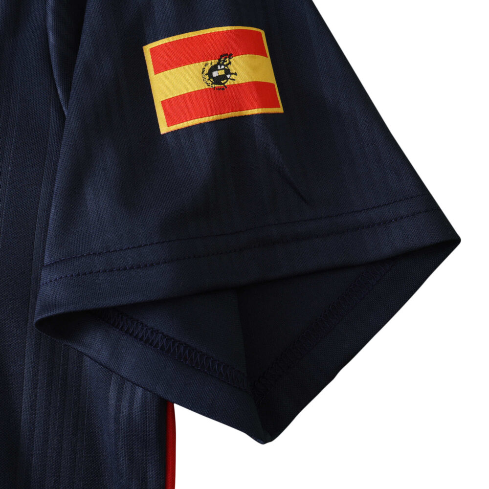 Close-up of the Spain Retro Home 1996 fan version jersey sleeve with flag patch.