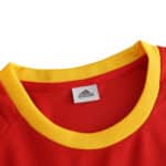 Close-up of the collar of the Spain Retro Home 2002 Fan Version jersey, featuring a red and yellow design with an Adidas logo.