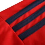 Close-up of the Spain Retro Home 2002 Fan Version jersey, showcasing red fabric with dark blue stripes.