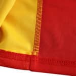 Close-up view of the Spain Retro Home 2002 Fan Version jersey showing red and yellow fabric with detailed stitching.