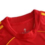 Close-up of the collar and chest area of Spain Retro Home 2008 Fan Version soccer jersey in red with yellow accents.