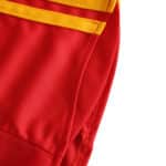 Close-up of Spain Retro Home 2008 Fan Version jersey showing red fabric with yellow stripes detail.