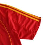 Close-up of the sleeve of Spain Retro Home 2008 Fan Version jersey, featuring red fabric with yellow stripes.