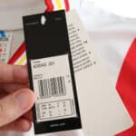 Close-up of the Spain Retro Third 1996 Fan Version jersey tag, showing brand and sizing information.