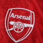 Close-up of the Arsenal FC crest on the 2025/26 Home Player Version jersey, showing red fabric detail.
