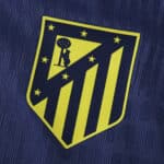 Atlético Madrid 2025/26 away player version kit crest on dark blue fabric background.