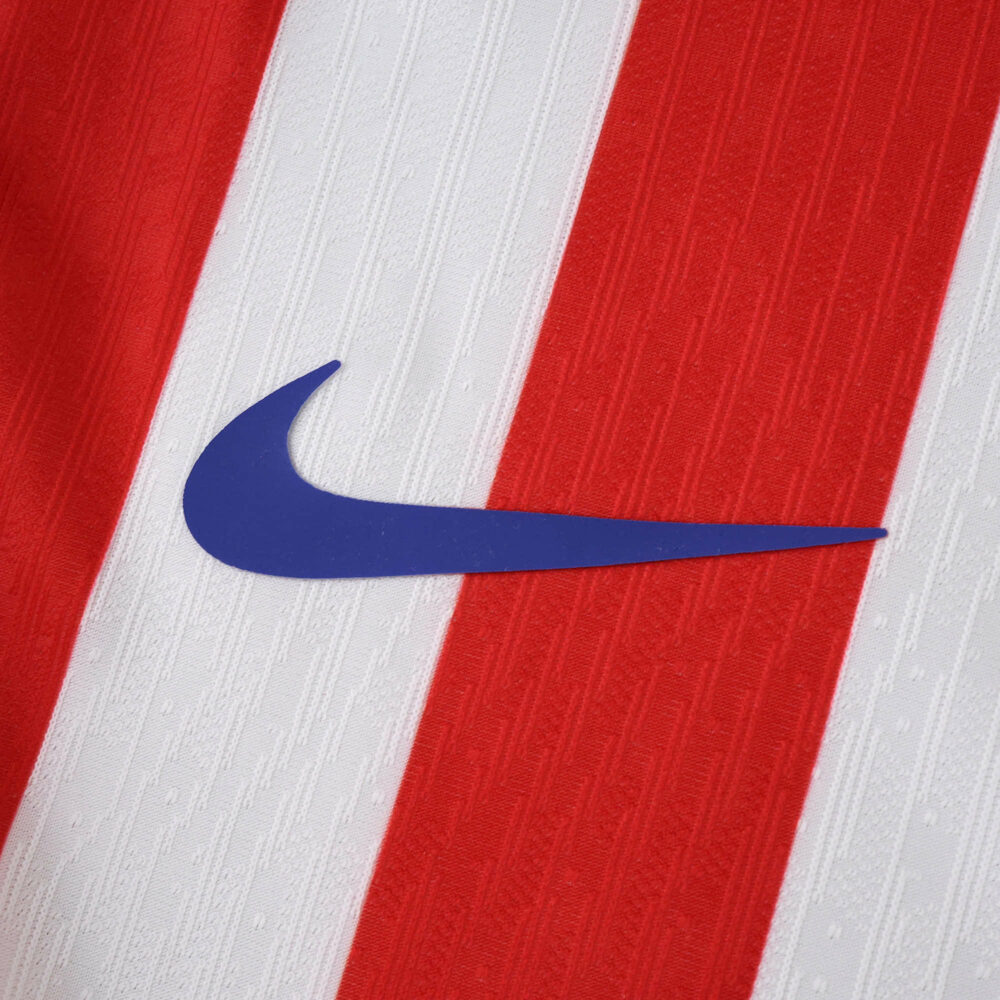 Close-up of the Atlético Madrid 2025/26 Home Player Version jersey with blue Nike logo on red and white stripes.