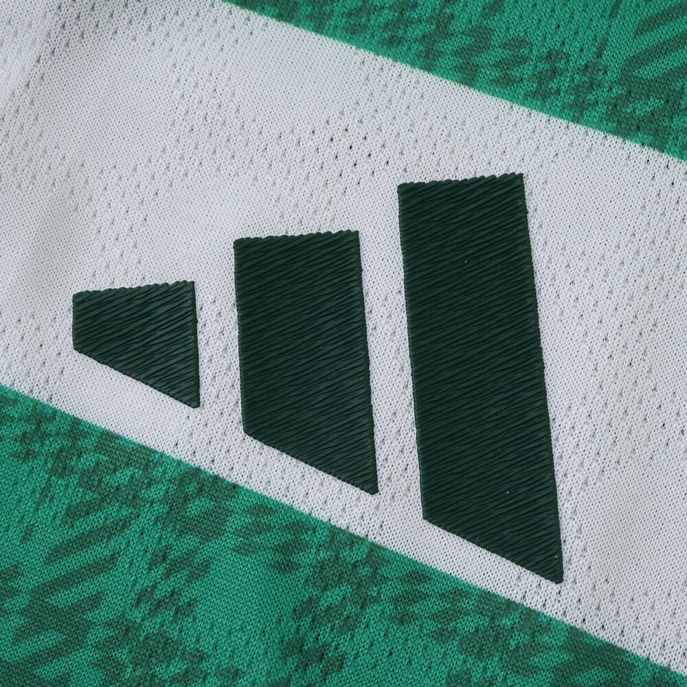Close-up of the Adidas logo on the Celtic Home 2025/26 Player Version jersey in green and white.