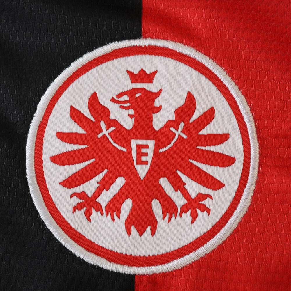Eintracht Frankfurt 2025/26 home fan jersey crest with red eagle on black and red background.