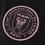 Inter Miami CF 2025/26 away fan jersey badge with pink club crest on black fabric.
