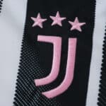 Juventus 2025/26 home fan jersey crest with three pink stars and pink team logo on black and white stripes.